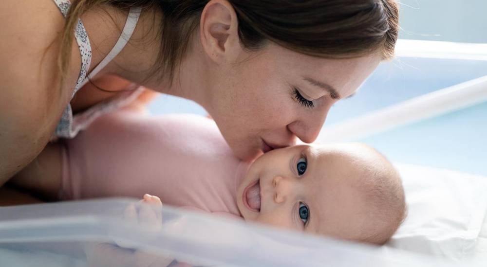 أم تقبّل طفلها حديث الولادة، تعبير عن نجاح الحمل والأمومة بعد علاج الخصوبة أم تقبّل طفلها حديث الولادة، تعبير عن نجاح الحمل والأمومة بعد علاج الخصوبة